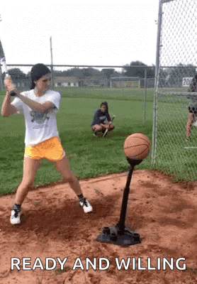 Girl Swinging Bat at Basketball on Tee Ball Stand