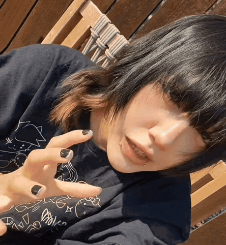 Girl With Black Nails And Black Shirt With Cartoon Drawing GIF