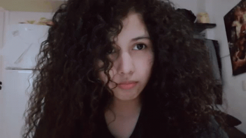 Girl With Curly Hair Looks at Camera