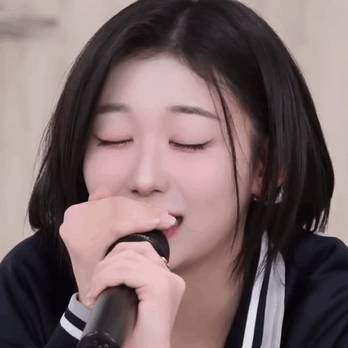 Girl With Eyes Closed Singing Into Microphone