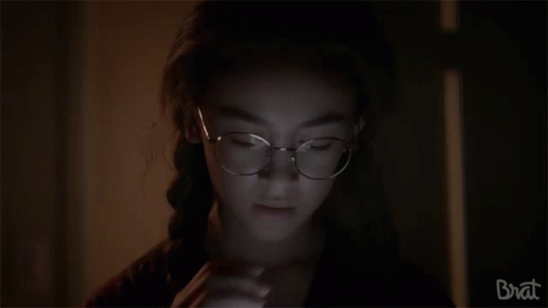 Girl With Glasses Looking in Dark Room