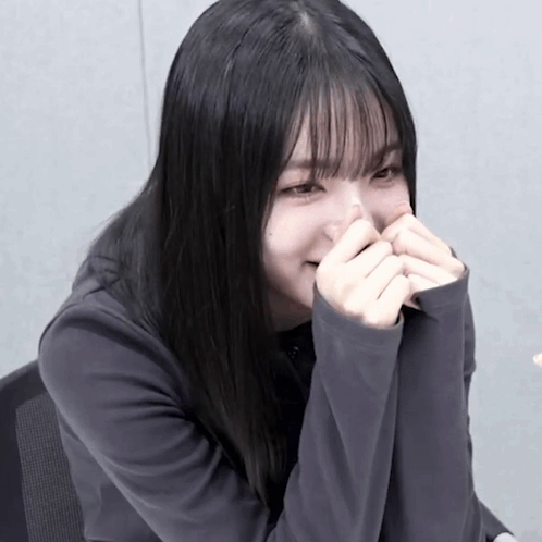 Girl with Long Black Hair Covering Mouth