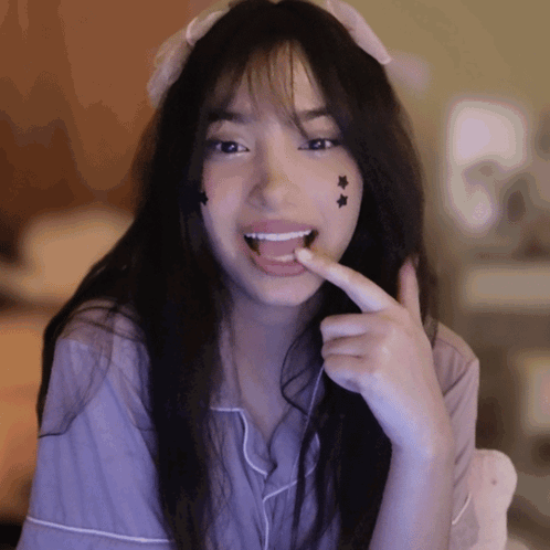 Girl With Star Face Smiling And Licking Finger GIF