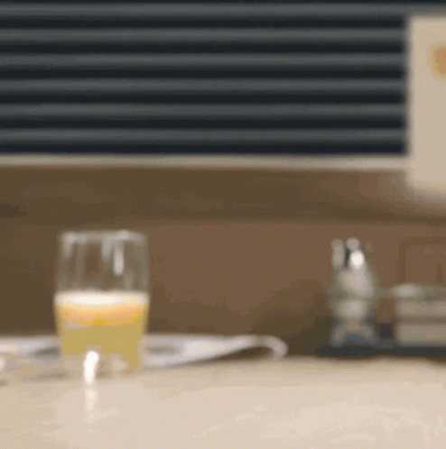 Glass of Orange Juice Next to Newspaper