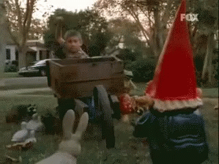 Gnome in Red Hat Laughing and Covering Mouth