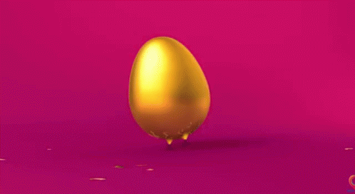 Golden Egg With Confetti on Pink Surface