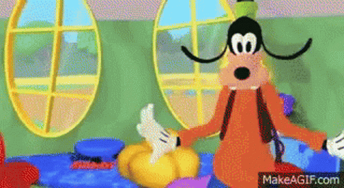 Goofy From Mickey Mouse Clubhouse Is Sitting On A Bed Holding A Pumpkin . GIF