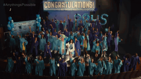 Graduates Standing In Front Of Congratulations Banner GIF