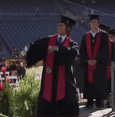 Graduates Standing in Front of Pet Sign