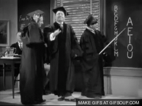 Graduation Gowns Standing in Front of Blackboard