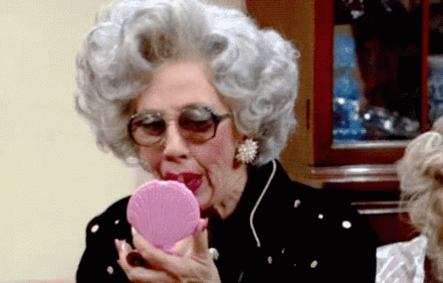 Gray-Haired Woman Looking In Pink Mirror GIF