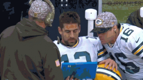 Green Bay Packers Player Number 18 Looking at Clipboard