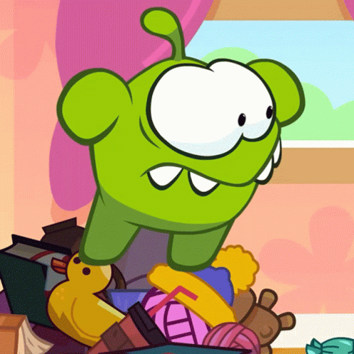 Green Cartoon Character Sitting on Toys