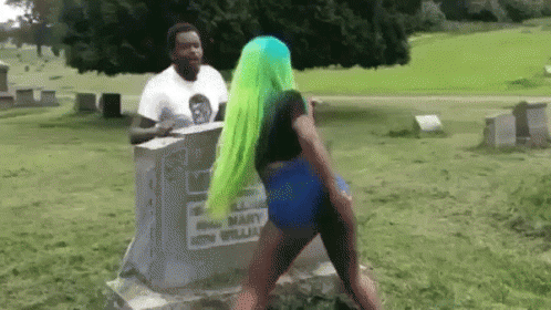 Green-Haired Woman Dancing at Grave in Cemetery