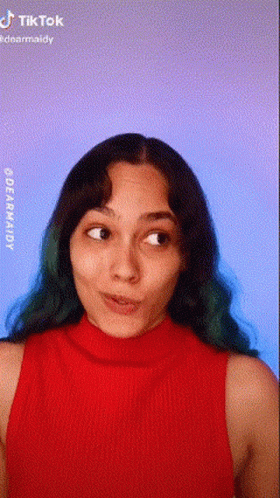 Green-Haired Woman Making Face in Red Tank Top