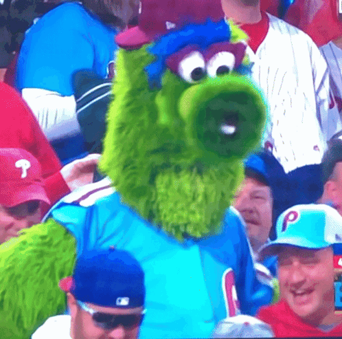Green Mascot In Blue Shirt With Letter P GIF