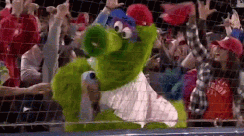 Green Mascot Standing in Front of Crowd