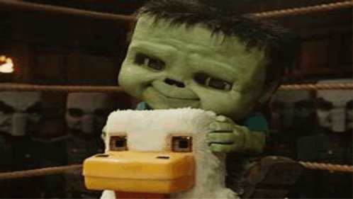Green Stuffed Animal On Chicken In Boxing Ring GIF
