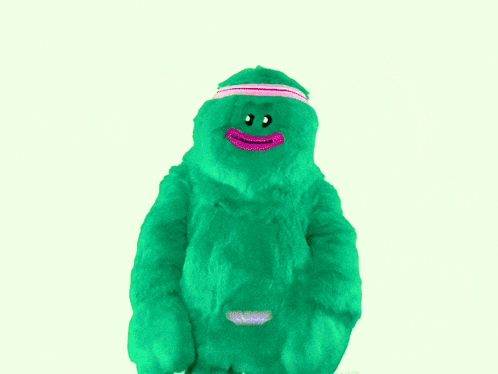 Green Stuffed Animal With Pink Headband Saying We Move