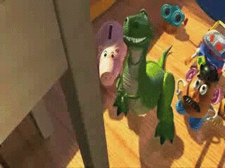 Green Toy Dinosaur Next to Potato Head