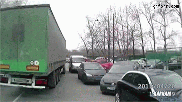 Green Truck Driving Through Parking Lot