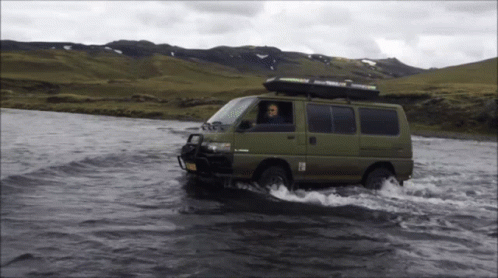 Green Van Driving Through River With Thule Roof Rack