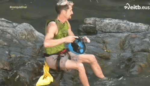 Green Vest Man on Rock in Water eitb.eus
