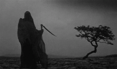 Grim Reaper Standing in Desert Holding Scythe
