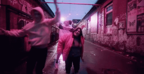 Group Dancing in Alleyway With Pink Lights