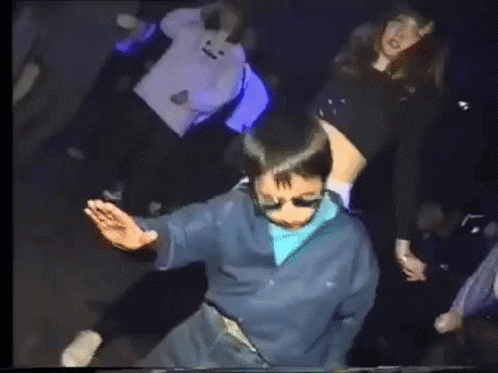 Group Dancing in Dark Room with Purple Lights