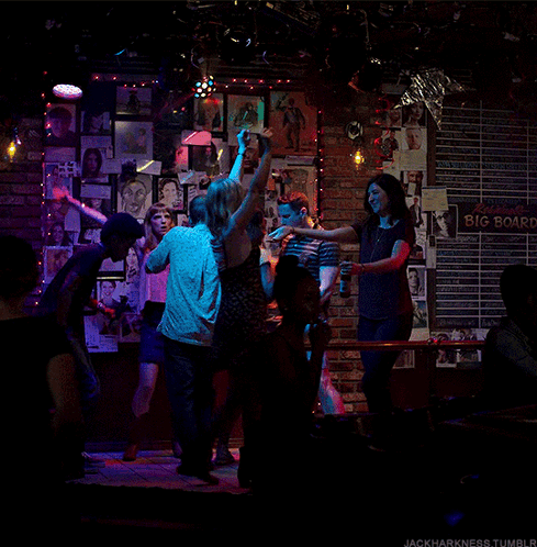 Group Dancing in Front of Big Board