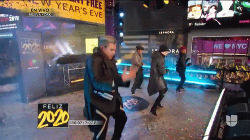 Group Dancing In Front Of Year's Eve Sign GIF