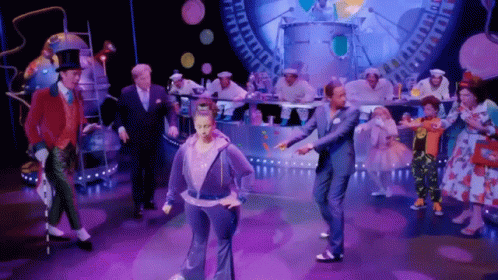 Group Dancing on Stage, One in Purple Hoodie