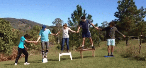 Group Holding Hands Standing On Chairs GIF