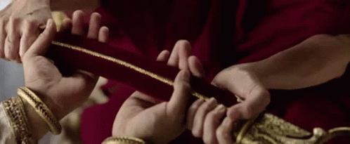 Group Holding Red Cloth With Gold Trim