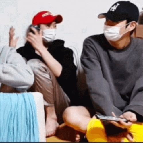 Group in Face Masks and Hats Playing Video Game