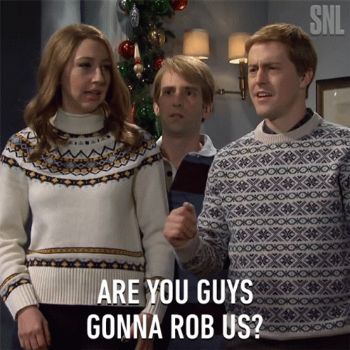 Group in Front of Christmas Tree Saying Are You Guys Gonna Rob Us
