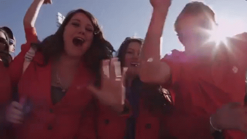Group in Red Jackets Cheering With Hands Up