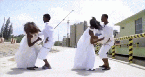 Group in White Clothes Standing on Sidewalk