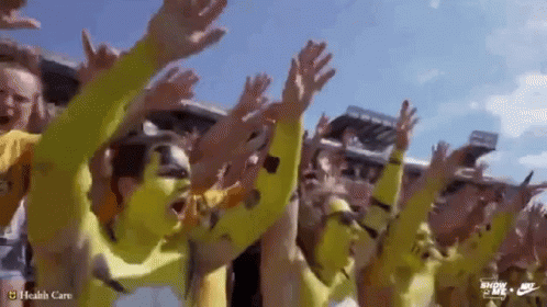 Group in Yellow Shirts Raising Hands