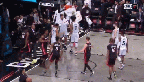 Group of Basketball Players on Court With Geico Sign