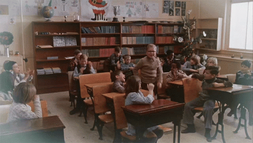 Group of Children in Classroom with Merry Christmas Sign