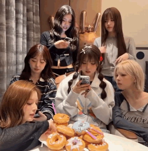 Group of Girls Sitting Around Table With Donuts