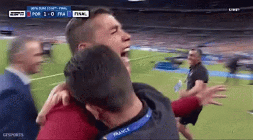 Group of Men Hugging on Soccer Field