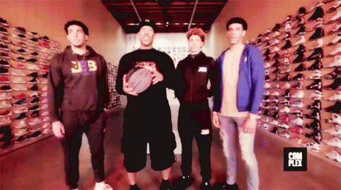 Group of Men in Front of Shoe Wall Saying Com Plex