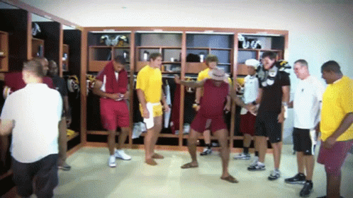 Group of Men in Locker Room One Wearing Hat