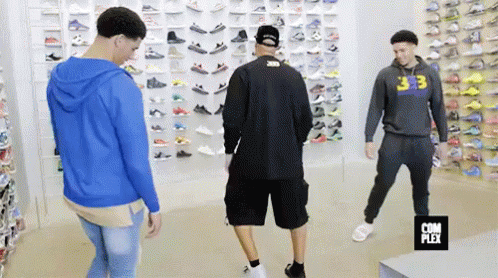 Group Of Men In Shoe Store Looking At Shoes GIF