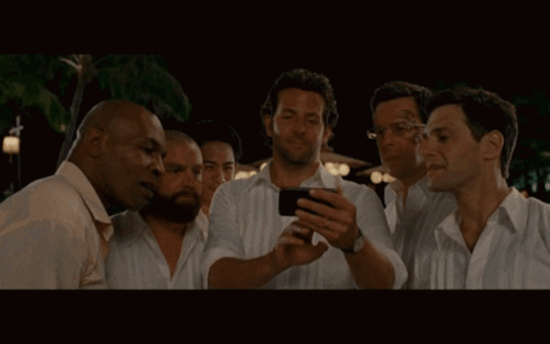 Group of Men Looking at Phone Together