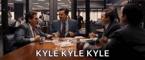Group Of Men Sitting Around Table Saying Kyle Kyle Kyle GIF