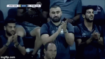 Group of Men Sitting in Stadium Clapping